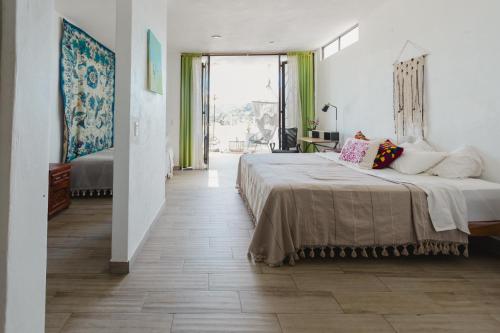 1 dormitorio con cama grande y ventana grande en Casa Fenix, en Sayulita