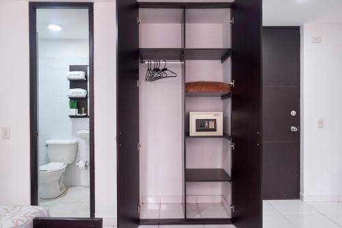 ein Bad mit einem Spiegel und einem WC in der Unterkunft Icon 48 Studio 451 By Pmi in Bogotá