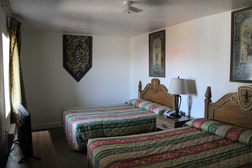 a hotel room with two beds with colorful sheets at Flagstaff Motel in Flagstaff