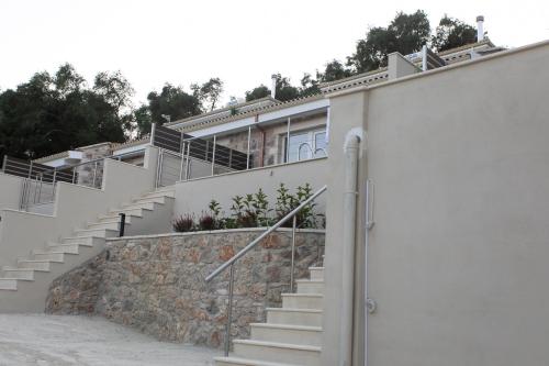 a house with stairs and a stone wall at Elais Luxury Villas in Parga