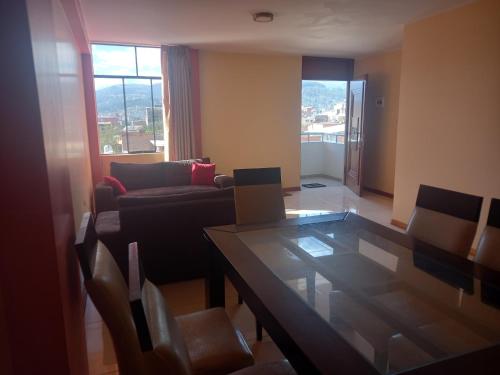 a living room with a glass table and a couch at Departamento céntrico in Huaraz