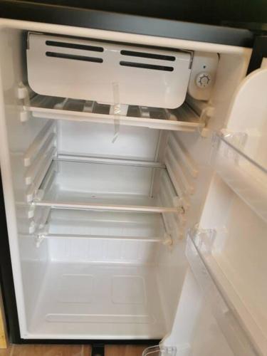an empty refrigerator with its door open and itsartmentssenalsenalsenalsenalsenalangering at MaaR Estudios 6, a 2 cuadras del Malecón de La Paz in La Paz