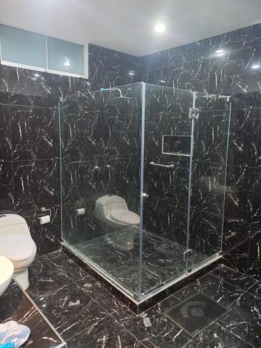 y baño con ducha de cristal y aseo. en Casa de Campo Las Tujas, en Lunahuaná