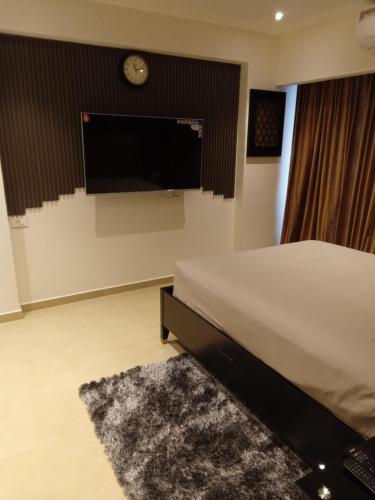 Schlafzimmer mit einem Bett und einem Flachbild-TV in der Unterkunft KMAX PROPERTY in Accra