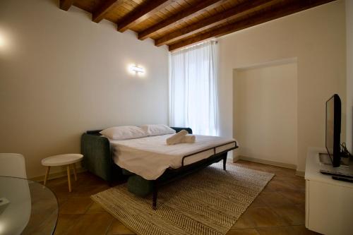 een slaapkamer met een bed in een kamer met een raam bij Dolce Vita Apartment - Salò in Salò