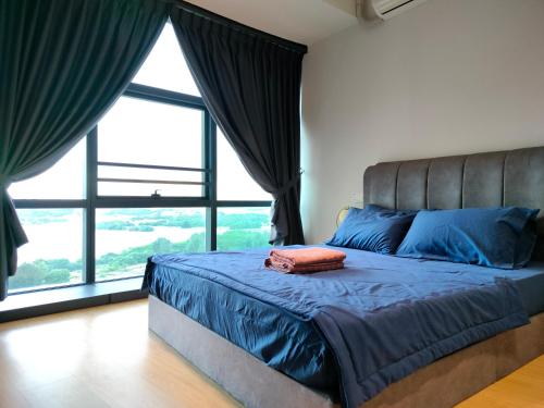 een slaapkamer met een bed met blauwe lakens en een groot raam bij DangaBay SeaView 4pax with Netflix WiFi in Johor Bahru