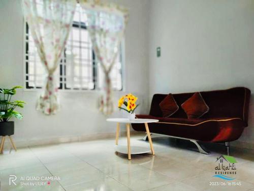 een woonkamer met een bank en een tafel bij Qalya Homestay 1 @ Kota Bharu in Kota Bharu