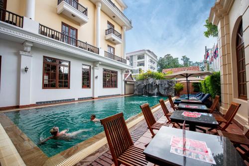 Una pareja nadando en una piscina en una casa en Royal Crown Hotel & Spa, en Siem Reap