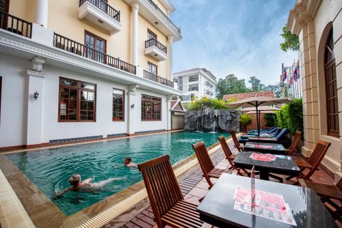 a couple swimming in a pool in a house at Royal Crown Hotel & Spa in Siem Reap