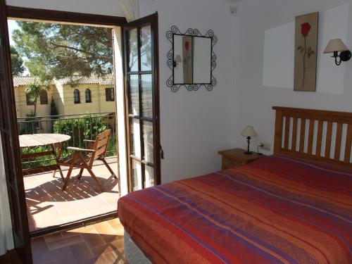 1 dormitorio con 1 cama y balcón con mesa en Casa Atenes, en L'Estartit