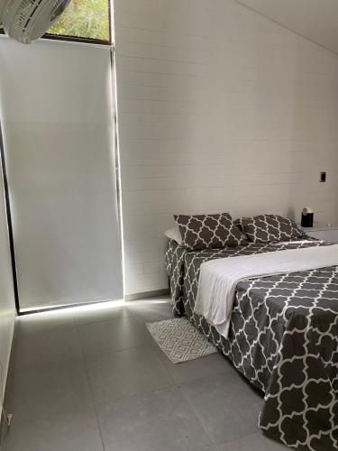 um quarto com uma cama e uma janela em Casa de campo bali 03 em Sopetran