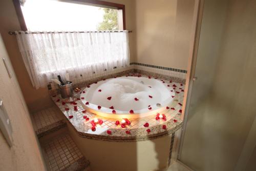 a bathroom with a bath tub with lights in it at Pousada Varanda das Colinas in Monte Verde