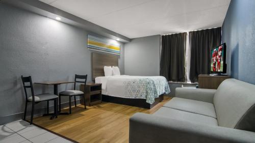 um quarto de hotel com uma cama, uma mesa e cadeiras em HomeTowne Studios by Red Roof Chicago - N Aurora-Naperville em North Aurora