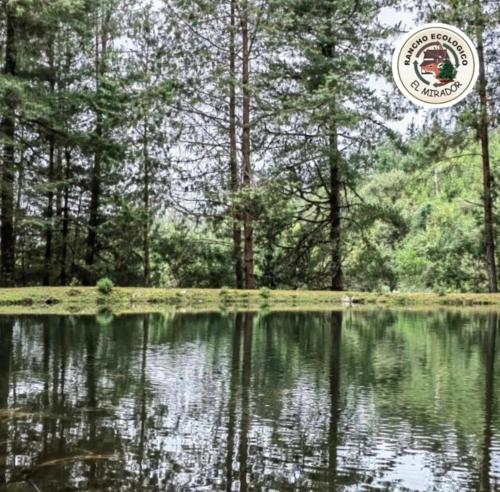 une photo d'un lac avec des arbres en arrière-plan dans l'établissement Rancho Ecológico El Mirador, à Acajete