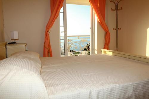 a bedroom with a white bed and a large window at Villa in the sea Crete in Stavros