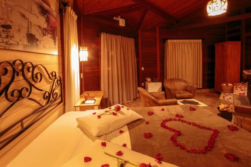 Un dormitorio con una cama con rosas. en Pousada Varanda das Colinas, en Monte Verde