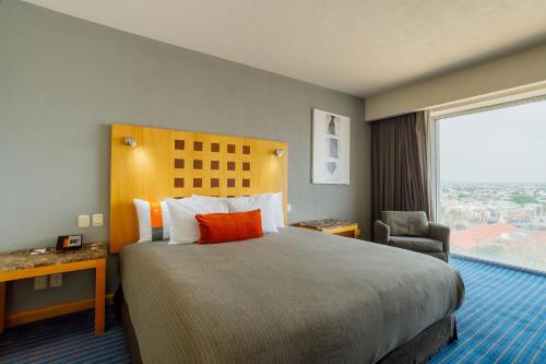 a hotel room with a large bed and a window at Real Inn Ciudad Juarez by the USA Consulate in Ciudad Juárez