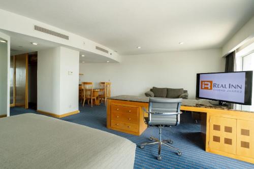 a hotel room with a desk with a television on it at Real Inn Ciudad Juarez by the USA Consulate in Ciudad Juárez