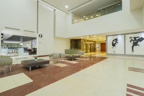 a lobby with tables and chairs in a building at Real Inn Ciudad Juarez by the USA Consulate in Ciudad Juárez