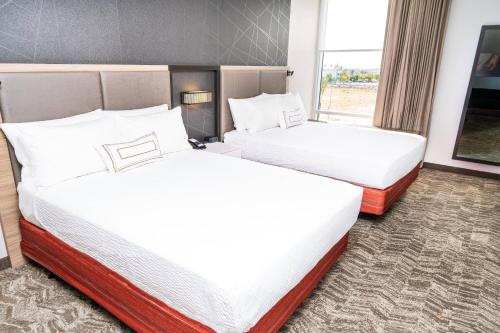 a hotel room with two beds and a window at SpringHill Suites by Marriott Ontario Airport/Rancho Cucamonga in Ontario