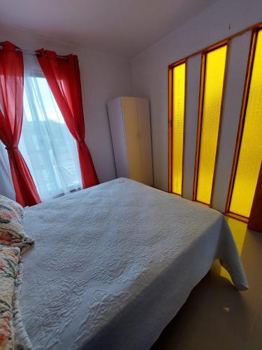 a bedroom with a bed with red and yellow curtains at Encanto Rural - Casa de campo para disfrutar y olvidar el estrés in Putaendo