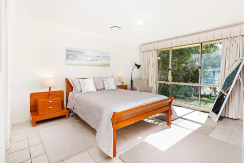 a bedroom with a bed and a large window at Bella Vista in Gerringong