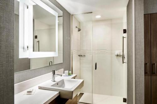 a white bathroom with a sink and a shower at SpringHill Suites by Marriott Oklahoma City Midwest City Del City in Del City