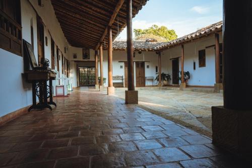 an empty courtyard of a building with a stone floor at Hotel Finca Buenos Aires Barichara in Barichara