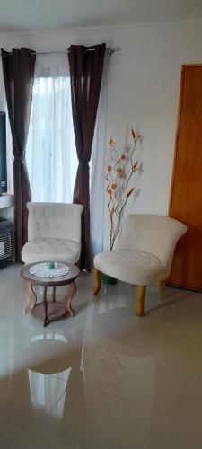 a living room with a chair and a table and a window at Encanto Rural - Casa de campo para disfrutar y olvidar el estrés in Putaendo