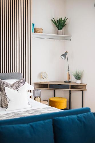 a bedroom with a bed and a desk with a lamp at Eden Grove - Islington - Studio Apartment in London