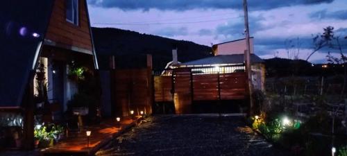 una casa con luces al costado de ella por la noche en Paluna cabaña en San Martín de los Andes