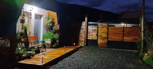 una casa con una terraza con una puerta por la noche en Paluna cabaña en San Martín de los Andes