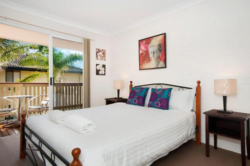 a bedroom with a bed and a balcony at Shivas@Byron... minutes walk to Main Beach! in Byron Bay
