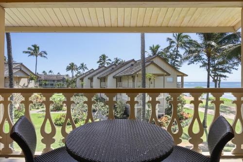 a balcony with a table and chairs looking out at the beach at Aston Islander On The Beach in Kapaa