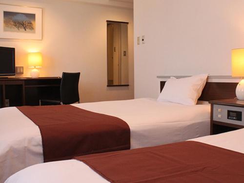 Un pat sau paturi într-o cameră la HOTEL LiVEMAX BUDGET Iyo Mishima