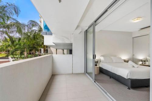 a bedroom with a bed and a balcony at Modern Riverside Oasis - Gym Pool WiFi & Parking in Brisbane