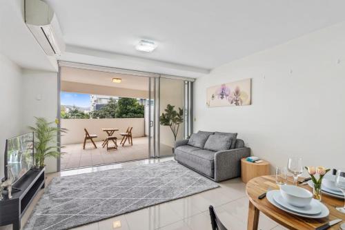 a living room with a couch and a table at Modern Riverside Oasis - Gym Pool WiFi & Parking in Brisbane
