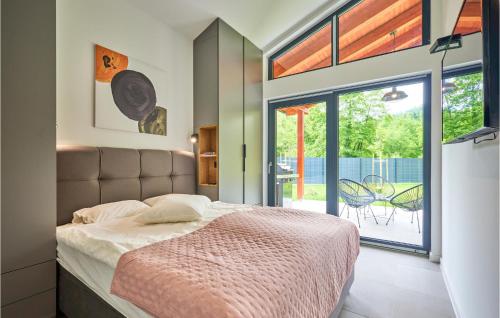 1 dormitorio con cama y ventana grande en Pet Friendly Home In Brezova Gora With Sauna, 