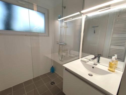 une salle de bain blanche avec un lavabo et une douche dans l'établissement Maison à Perros-Guirec avec WiFi à 550m de la plage de Trestraou - FR-1-368-368, à Perros-Guirec