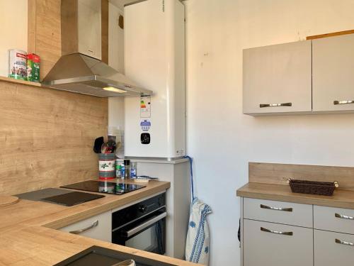 une cuisine avec une cuisinière et un réfrigérateur dans l'établissement Appartement à 2 pas de la plage de Mèze, climatisé, parking gratuit, labelisé 2 clés CLEVACANCES - FR-1-604-40, à Mèze