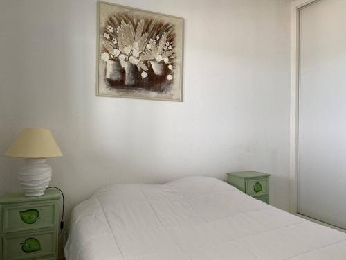 een slaapkamer met een wit bed en twee groene nachtkastjes bij Appartement Trégastel, 2 pièces, 4 personnes - FR-1-368-396 in Trégastel