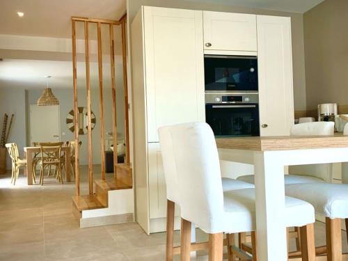 une cuisine et une salle à manger avec une table et des chaises dans l'établissement Maison rénovée avec garage et terrasses à Mèze - FR-1-604-43, à Mèze