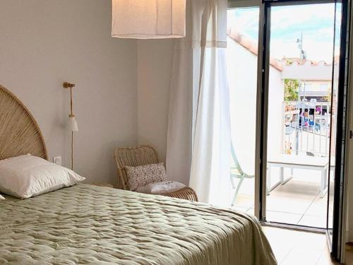 une chambre avec un lit et une vue sur un balcon dans l'établissement Maison rénovée avec garage et terrasses à Mèze - FR-1-604-43, à Mèze