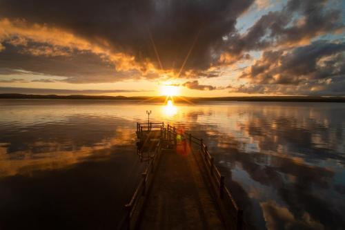 una puesta de sol en un lago con la puesta de sol en Tadaya, en Nanao