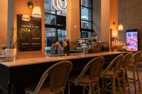 a bar with a row of chairs at a restaurant at The Riche Boutique Hotel Don Mueang Airport in Bangkok