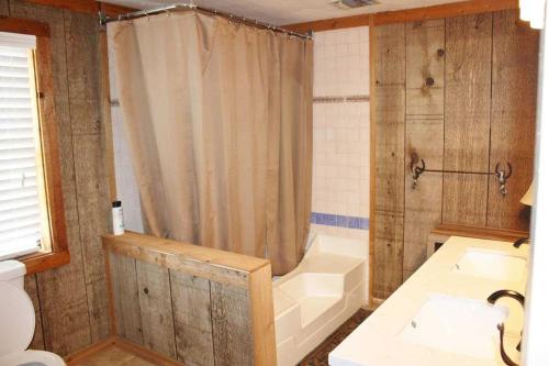 a bathroom with a shower and a tub and a sink at Rockin' B Ranch Bluff House in Pipe Creek