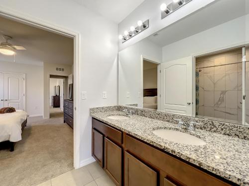 a bathroom with two sinks and a large mirror at 7 Bedroom 6 Bath Home with Private Pool Spa Walk to Solterra Clubhouse Lazy River 20 min from Disney in Davenport