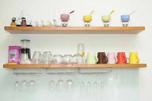a bunch of glasses on shelves on a wall at 3520 Homestay in Taitung City
