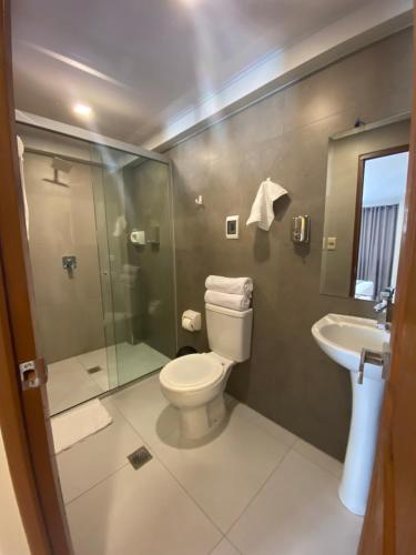 a bathroom with a toilet and a shower and a sink at Izza Hotel in Cochabamba