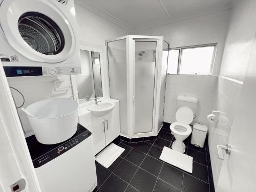 a white bathroom with a sink and a toilet at Gladstone Gem 6 - Suva CBD 2bdrm Apts in Suva